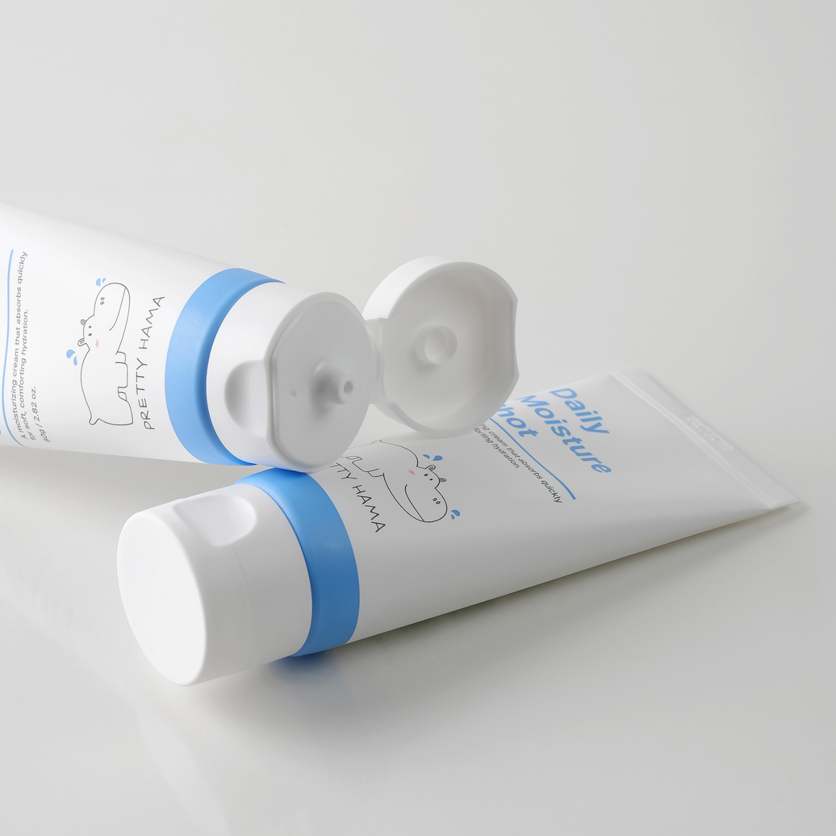 Two Pretty Hama Daily Moisture Shot face moisturizer tubes, one with its flip-top cap open, on a white background